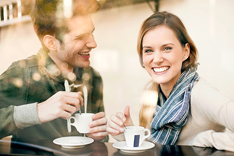 A couple smiling and enjoying a coffee together